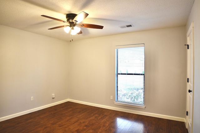 spare room featuring dark wood finished floors, baseboards, a textured ceiling, and ceiling fan