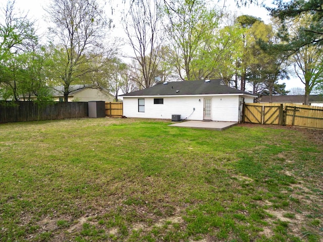 back of house with a yard, a fenced backyard, and a patio