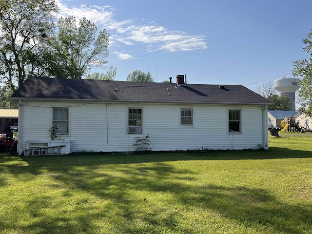 back of house with cooling unit, a yard, and a chimney