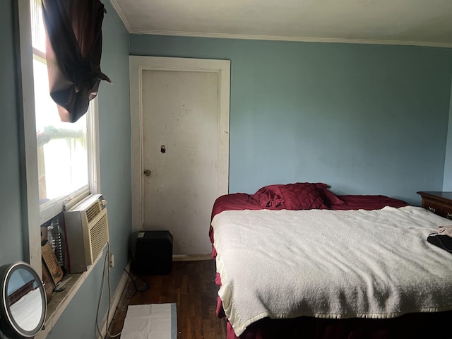 bedroom with baseboards, wood finished floors, and ornamental molding