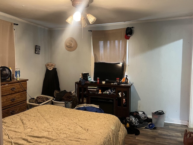 bedroom with baseboards, wood finished floors, ceiling fan, and crown molding