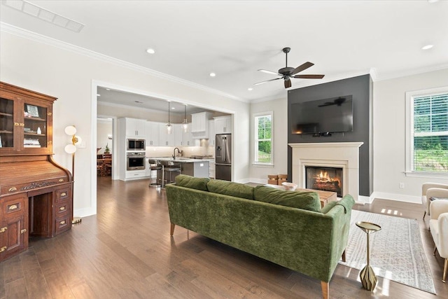 428 Catawba Valley Dr, Collierville, TN 38017 - living room featuring a warm lit fireplace, crown molding, and dark wood-style floors