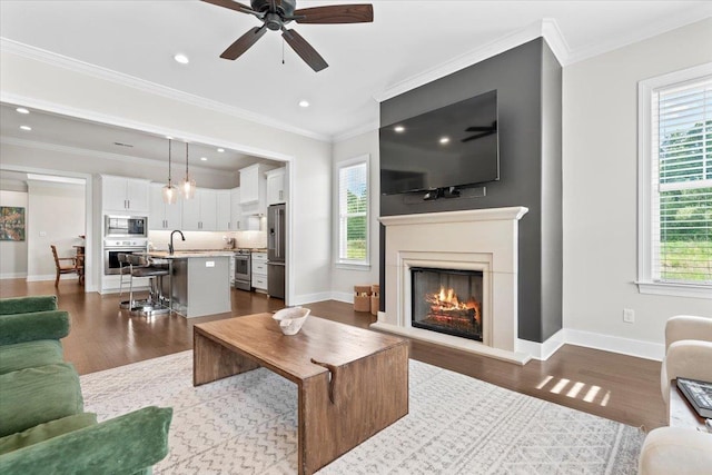 428 Catawba Valley Dr, Collierville, TN 38017 - living room featuring a warm lit fireplace, a ceiling fan, baseboards, and dark wood-style flooring