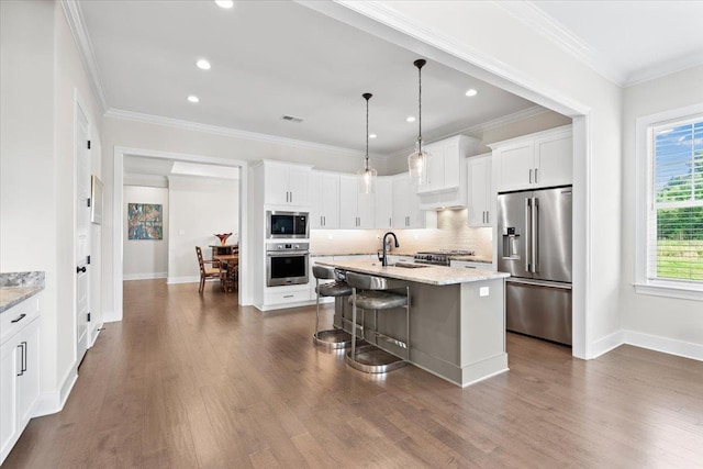 428 Catawba Valley Dr, Collierville, TN 38017 - kitchen featuring appliances with stainless steel finishes, a sink, white cabinetry, and a breakfast bar area