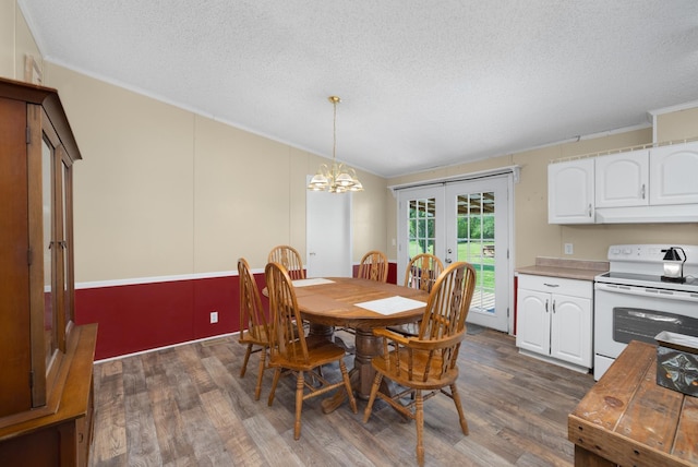 dining room with french doors, dark wood-style flooring, a textured ceiling, and crown molding
