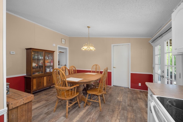 dining room featuring a chandelier, a textured ceiling, dark wood-type flooring, and ornamental molding