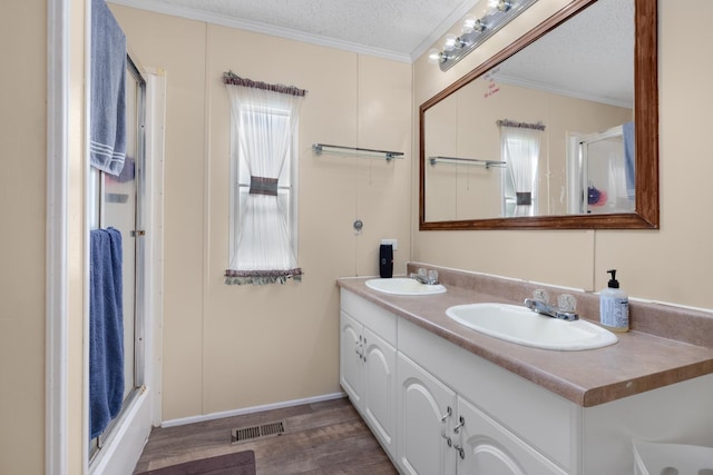 full bath with a shower stall, crown molding, a sink, and visible vents