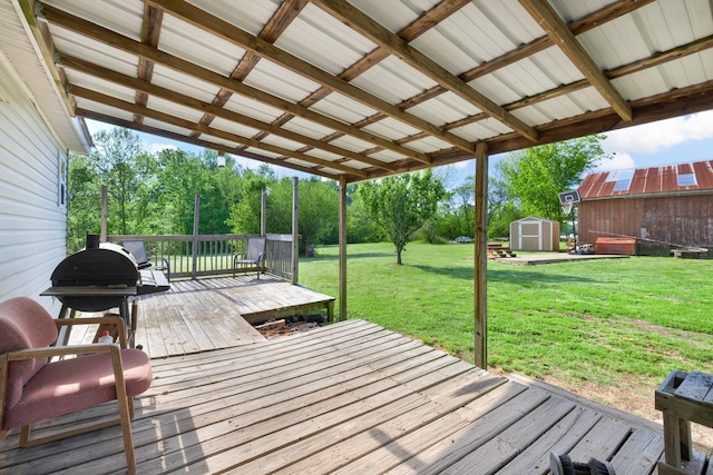 wooden terrace featuring an outdoor structure, a yard, and a shed