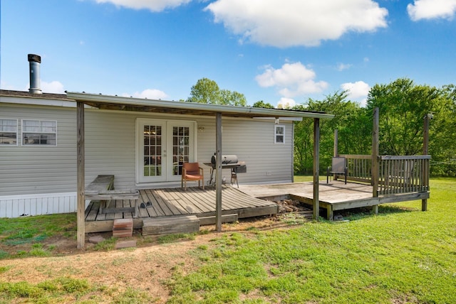 rear view of property with a wooden deck, a yard, and french doors