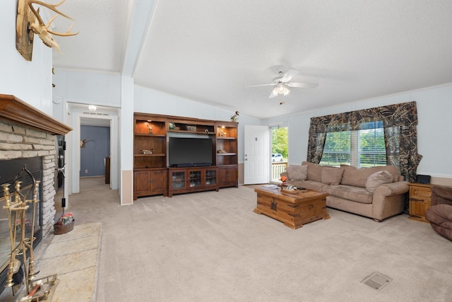 living room featuring light carpet, a textured ceiling, lofted ceiling, a ceiling fan, and a brick fireplace