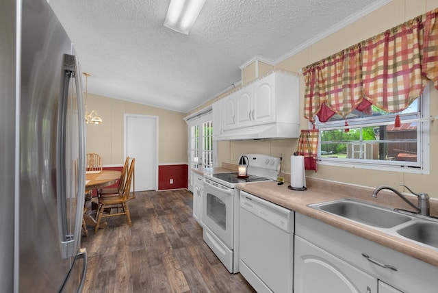 kitchen featuring under cabinet range hood, vaulted ceiling, a sink, white appliances, and a textured ceiling
