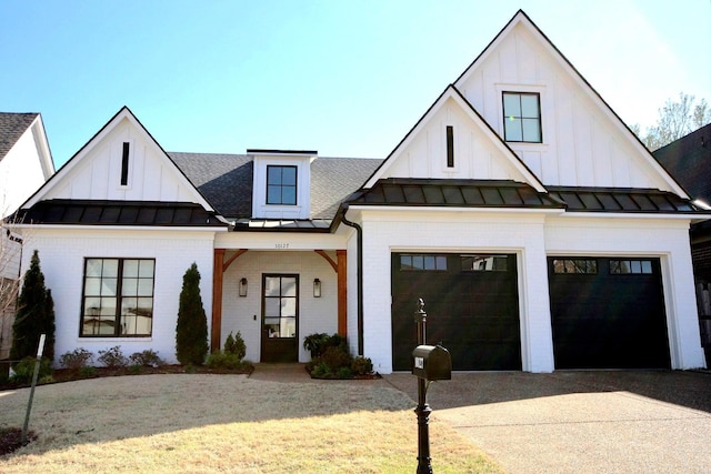 view of front of house featuring driveway, board and batten siding, metal roof, brick siding, and a standing seam roof