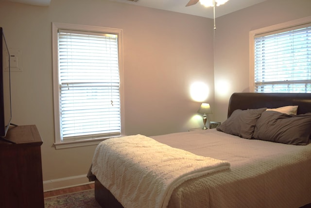 bedroom featuring wood finished floors, baseboards, and a ceiling fan