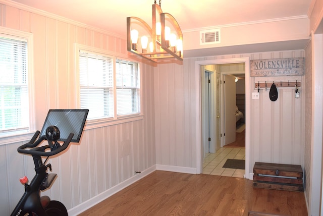dining space featuring plenty of natural light, visible vents, a chandelier, wood finished floors, and crown molding
