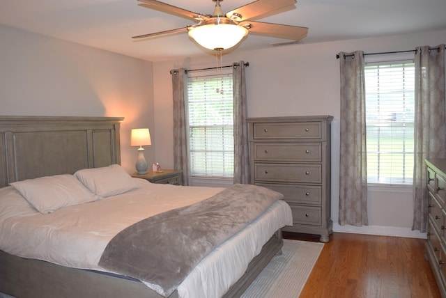 bedroom with baseboards, visible vents, multiple windows, and light wood finished floors