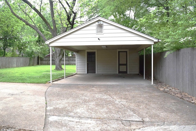 exterior space with concrete driveway, a fenced backyard, a front yard, and a carport