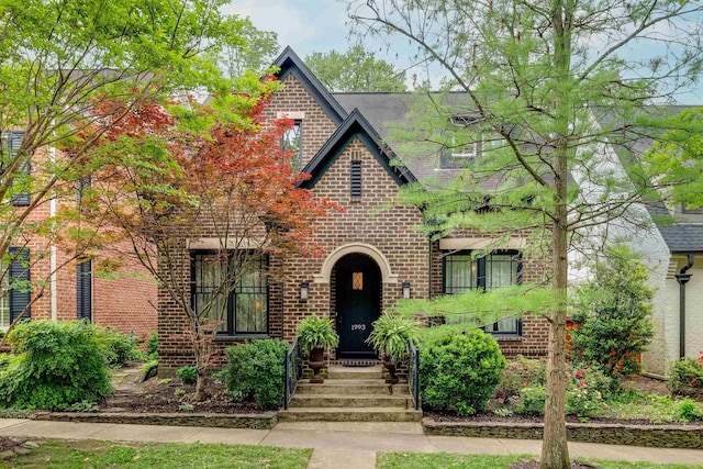 english style home featuring brick siding