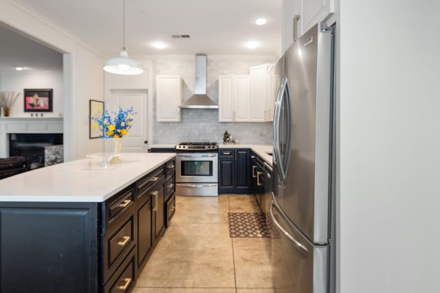 kitchen with backsplash, stainless steel appliances, light countertops, white cabinets, and wall chimney exhaust hood