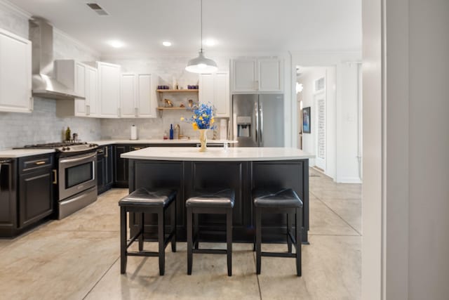 kitchen featuring wall chimney exhaust hood, light countertops, visible vents, and appliances with stainless steel finishes