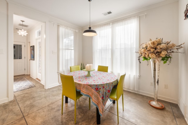 dining space featuring a chandelier, visible vents, crown molding, and baseboards