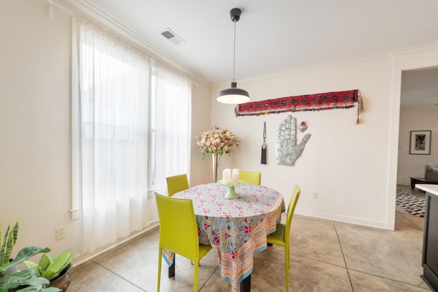 dining room with visible vents, crown molding, baseboards, and light tile patterned floors