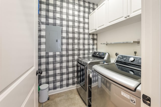 clothes washing area featuring washing machine and clothes dryer, electric panel, wallpapered walls, and cabinet space