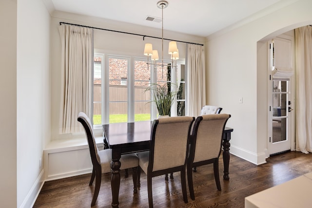 dining room with visible vents, baseboards, dark wood finished floors, and arched walkways