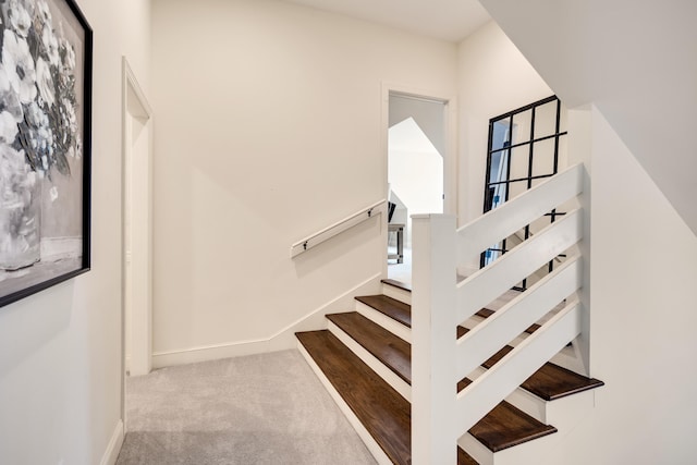 staircase featuring carpet and baseboards