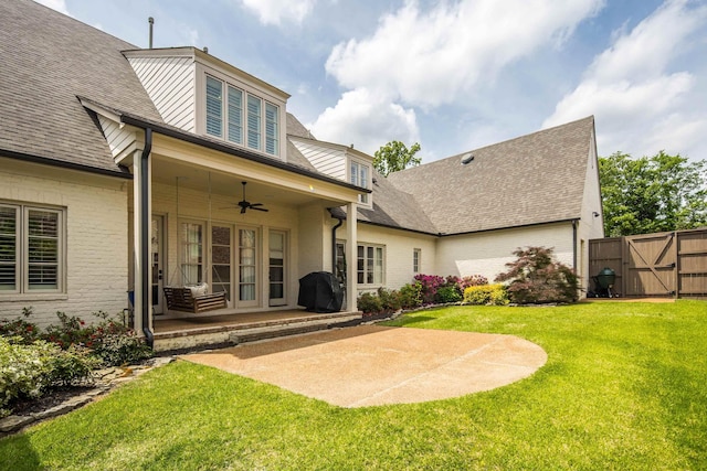 rear view of house with brick siding, ceiling fan, a yard, and a patio area