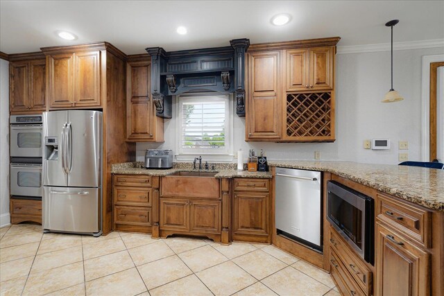 kitchen with appliances with stainless steel finishes, light stone countertops, and brown cabinetry