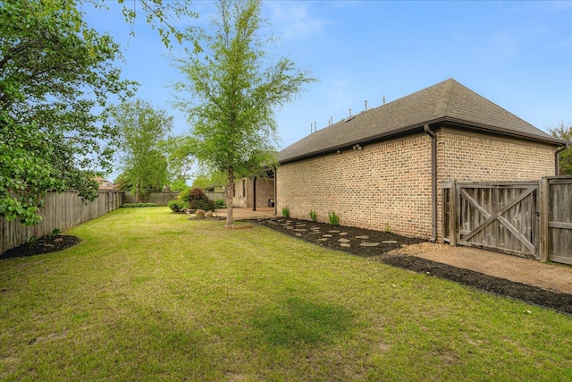 view of yard featuring a gate and a fenced backyard