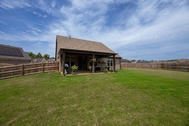 rear view of property with a patio, a fenced backyard, and a yard