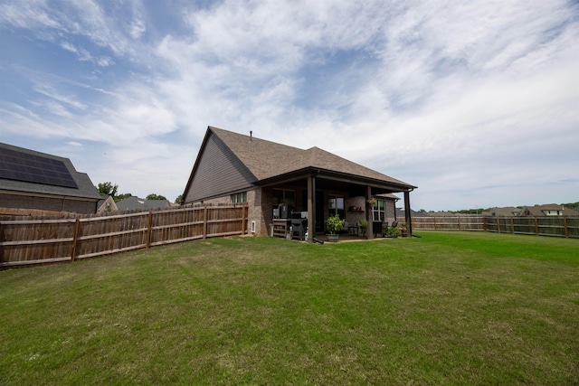 rear view of property featuring a lawn, a patio, and a fenced backyard
