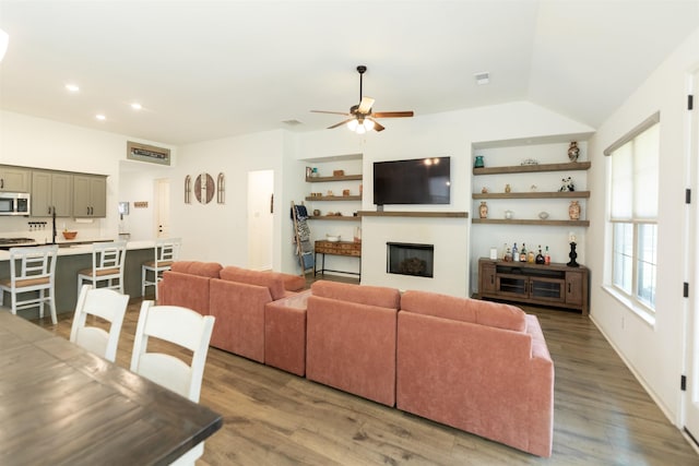 living room with a fireplace, wood finished floors, ceiling fan, and recessed lighting