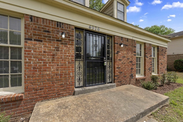 doorway to property with brick siding