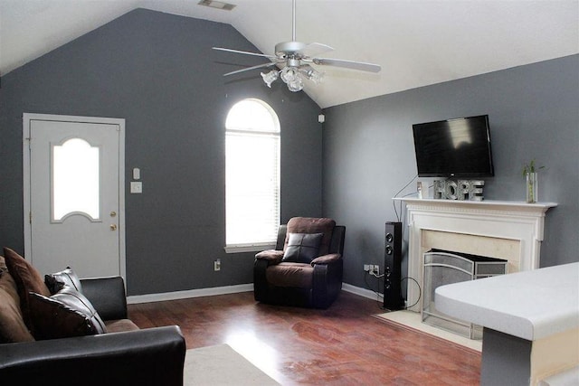 living room with a fireplace with flush hearth, visible vents, vaulted ceiling, wood finished floors, and a ceiling fan