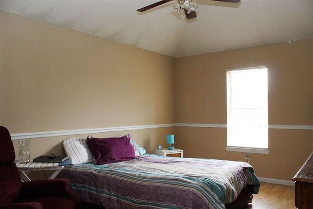 bedroom with baseboards, wood finished floors, ceiling fan, and vaulted ceiling