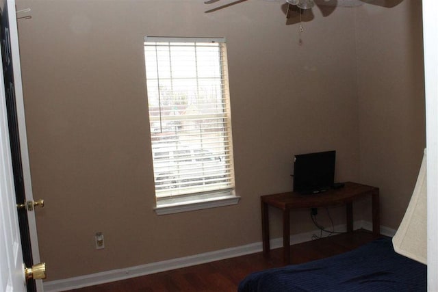 bedroom featuring baseboards, wood finished floors, and ceiling fan