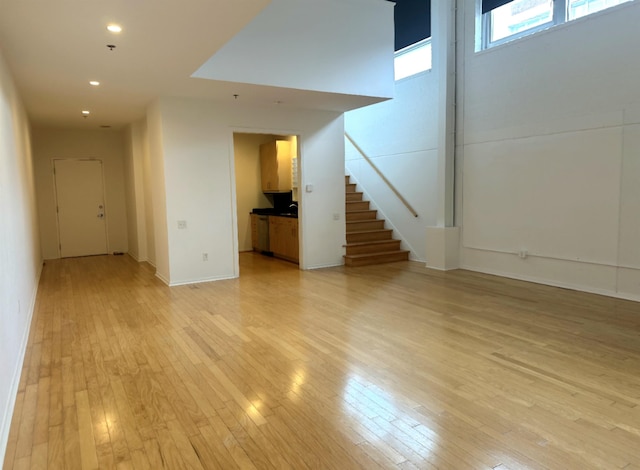 415 S Front St Unit 120, Memphis, TN 38103 - unfurnished living room featuring recessed lighting, stairs, light wood-style flooring, and baseboards