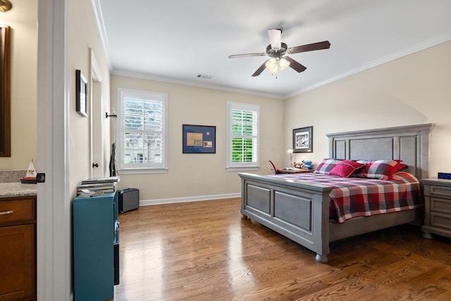 bedroom featuring crown molding, visible vents, ceiling fan, baseboards, and wood finished floors