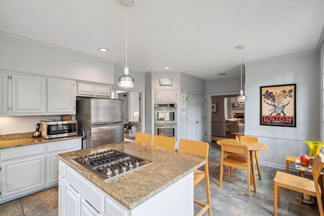 kitchen with appliances with stainless steel finishes, white cabinetry, light stone countertops, and crown molding
