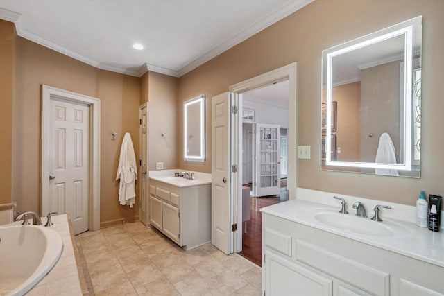 bathroom featuring a garden tub, crown molding, and a sink