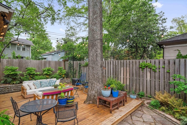 deck featuring outdoor dining space, an outdoor hangout area, and a fenced backyard