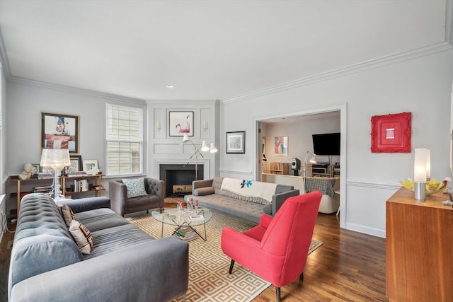 living room featuring ornamental molding, baseboards, wood finished floors, and a fireplace