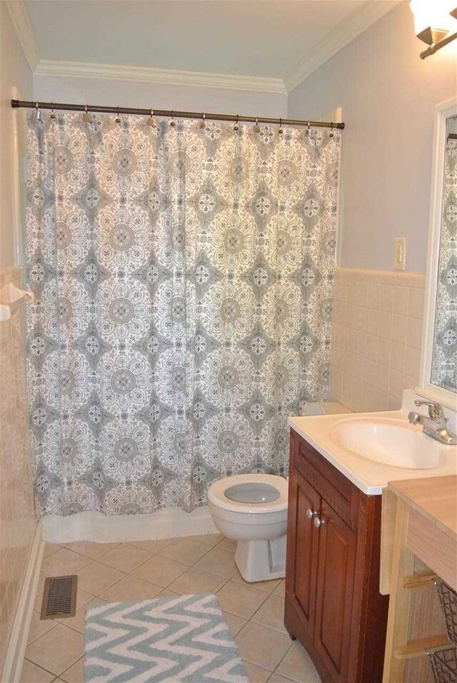 full bath with tile patterned floors, ornamental molding, a wainscoted wall, toilet, and vanity