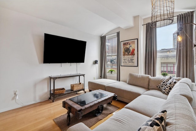 living room with baseboards, lofted ceiling, and wood finished floors