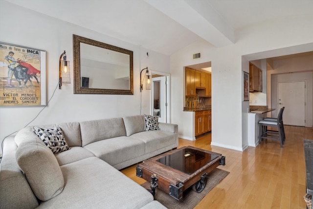living room with baseboards, light wood-type flooring, and visible vents