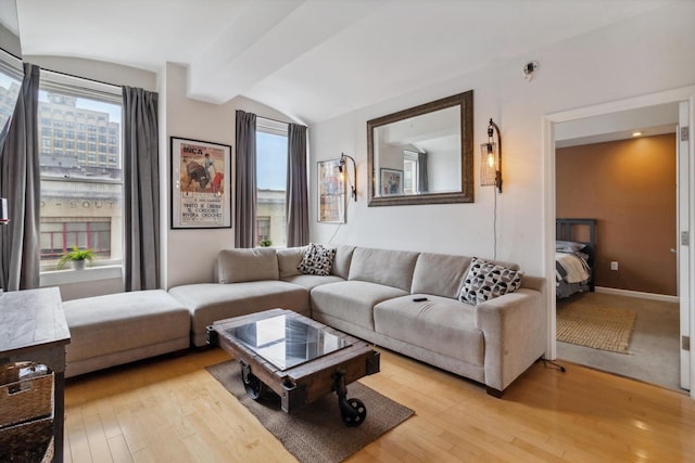 living room with baseboards, light wood finished floors, and lofted ceiling