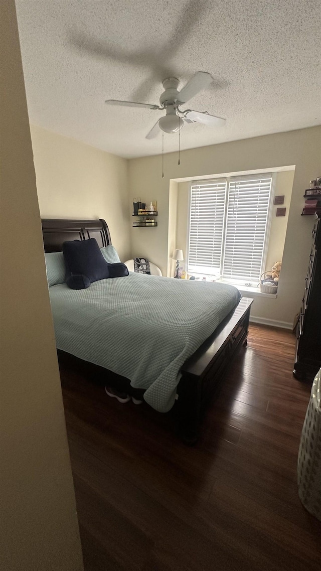 bedroom with baseboards, wood finished floors, ceiling fan, and a textured ceiling