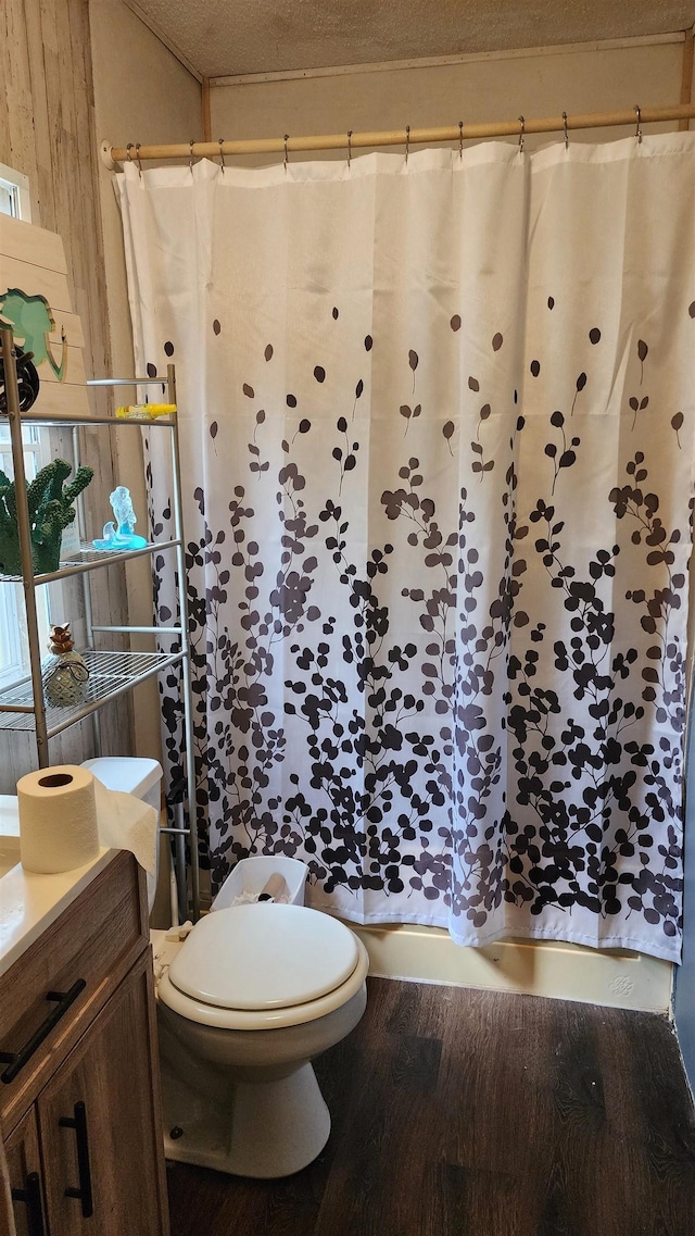 full bath featuring toilet, wood finished floors, and a shower with shower curtain